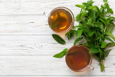 Arka planda bir fincan nane çayı. Fotokopi alanı ile taze nane görünümlü yeşil çay.