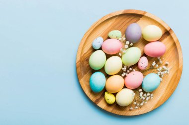 Mutlu Paskalya kompozisyonu. Paskalya yumurtaları renkli masada, çingeneyle birlikte. Doğal boyalı renkli yumurtalar arkaplan arkaplan görünümü kopya alanı ile.