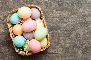 Mutlu Paskalya kompozisyonu. Paskalya yumurtaları renkli masada, çingeneyle birlikte. Doğal boyalı renkli yumurtalar arkaplan arkaplan görünümü kopya alanı ile.