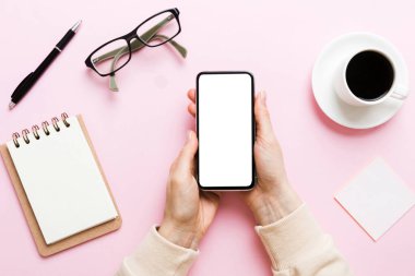 Mesajınız veya bilgi içeriğiniz için boş bir kopya ekranı olan akıllı telefonları tutan kadın ellerinin üst görünümü. üst görünümde telefon beyaz ekranı kullanan kadın eli.