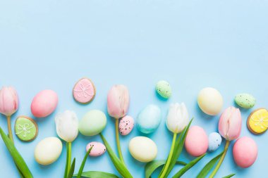 Mutlu Paskalya kompozisyonu. Renkli masada sarı laleli Paskalya yumurtaları. Doğal boyalı renkli yumurtalar arkaplan arkaplan görünümü kopya alanı ile.