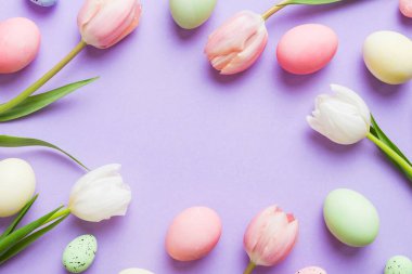 Mutlu Paskalya kompozisyonu. Renkli masada sarı laleli Paskalya yumurtaları. Doğal boyalı renkli yumurtalar arkaplan arkaplan görünümü kopya alanı ile.
