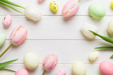 Mutlu Paskalya kompozisyonu. Renkli masada sarı laleli Paskalya yumurtaları. Doğal boyalı renkli yumurtalar arkaplan arkaplan görünümü kopya alanı ile.