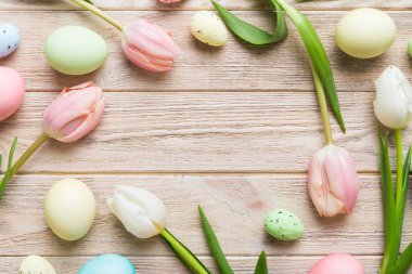 Mutlu Paskalya kompozisyonu. Renkli masada sarı laleli Paskalya yumurtaları. Doğal boyalı renkli yumurtalar arkaplan arkaplan görünümü kopya alanı ile.