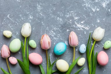 Mutlu Paskalya kompozisyonu. Renkli masada sarı laleli Paskalya yumurtaları. Doğal boyalı renkli yumurtalar arkaplan arkaplan görünümü kopya alanı ile.