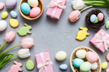 Yumurtalı Paskalya çerçevesi, renkli bir arka planda hediye kutusu ve lale. Minimum konsept. Üst Manzara Mutlu Paskalyalar kompozisyonu. Metin için yerin bir kopyasına sahip kart.