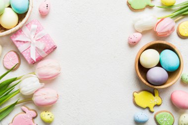 Yumurtalı Paskalya çerçevesi, renkli bir arka planda hediye kutusu ve lale. Minimum konsept. Üst Manzara Mutlu Paskalyalar kompozisyonu. Metin için yerin bir kopyasına sahip kart.