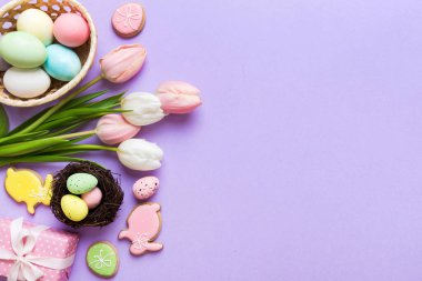 Yumurtalı Paskalya çerçevesi, renkli bir arka planda hediye kutusu ve lale. Minimum konsept. Üst Manzara Mutlu Paskalyalar kompozisyonu. Metin için yerin bir kopyasına sahip kart.