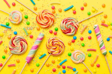 Lezzetli İştah açıcı Parti Aksesuarları Mutlu Yıllar Tatlı. Renkli arkaplanda farklı tipte şekerler, kopyalama alanı. Renkli doğum günü partisi geçmişi.