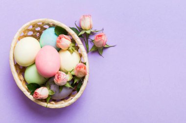 Mutlu Paskalyalar. Renkli masada sarı güllerle birlikte Paskalya yumurtaları. Doğal boyalı renkli yumurtalar arkaplan arkaplan görünümü kopya alanı ile.