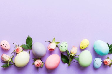 Mutlu Paskalyalar. Renkli masada sarı güllü Paskalya yumurtaları. Doğal boyalı renkli yumurtalar arkaplan arkaplan görünümü kopya alanı ile.