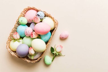 Mutlu Paskalyalar. Renkli masada sarı güllerle birlikte Paskalya yumurtaları. Doğal boyalı renkli yumurtalar arkaplan arkaplan görünümü kopya alanı ile.