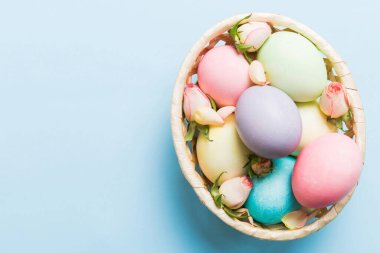 Mutlu Paskalyalar. Renkli masada sarı güllerle birlikte Paskalya yumurtaları. Doğal boyalı renkli yumurtalar arkaplan arkaplan görünümü kopya alanı ile.