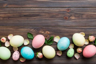 Mutlu Paskalyalar. Renkli masada sarı güllü Paskalya yumurtaları. Doğal boyalı renkli yumurtalar arkaplan arkaplan görünümü kopya alanı ile.