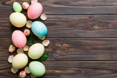 Mutlu Paskalyalar. Renkli masada sarı güllü Paskalya yumurtaları. Doğal boyalı renkli yumurtalar arkaplan arkaplan görünümü kopya alanı ile.