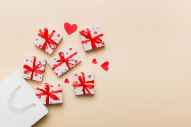 Gift boxes pop out from paper bag top view on colored background. bag packing handmade boxes fall out Concept of holidays, shopping, sale, discounts. Top view, flat lay.