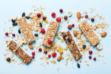 Arka planda çeşitli granola barlar var. Mısır gevreği gofretleri. Yulaf, fındık ve böğürtlenli kahvaltı barları, yakın çekim. Süper yiyecek konsepti.