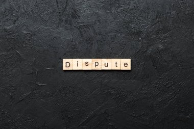 Tahta blokta yazan tartışmalı kelime. tablo üzerinde tartışmalı metin, kavram.