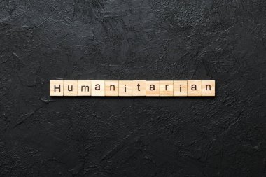 humanitarian word written on wood block. humanitarian text on table, concept. clipart