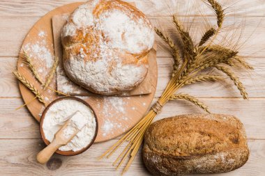 Tahtanın üzerinde beyaz ahşap zemine karşı taze pişmiş ekmek. Kopya alanı olan üst görünüm ekmeği.