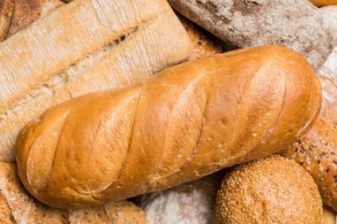 Ev yapımı doğal ekmek. Arka plan olarak farklı taze ekmek türleri, kopya alanı ile üst görünüm.