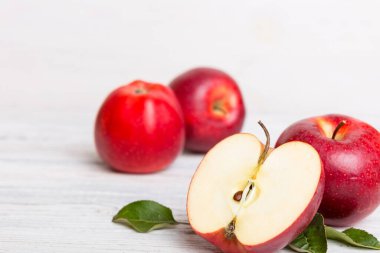 Tahta masada yeşil yapraklı taze kırmızı elmalar. Ahşap arka planda. Metin için üst görünüm boş alanı.