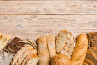 Ev yapımı doğal ekmek. Arka plan olarak farklı taze ekmek türleri, kopya alanı ile üst görünüm.