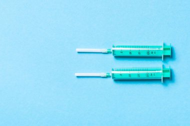 Renkli arka planda fotokopi alanı olan tıbbi şırıngaların üst görüntüsü. Enjeksiyon ekipmanı konsepti.