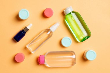 Kozmetik SPA marka modeli, fotokopi alanı olan üst görünüm. Renkli arka planda duran krema tüpleri ve kavanozları..