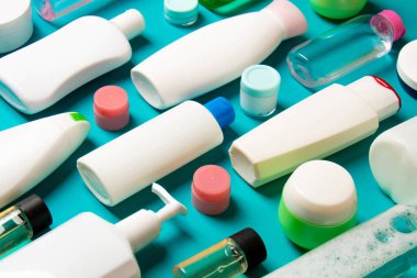 Plastik gövde bakımı şişesi düz kompozisyonu ve renkli arka plan boşluğuna kozmetik ürünler dizayn edilmişti. Beyaz Kozmetik kapları kümesi, kopya alanı ile üst görünüm.