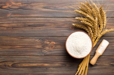 Tahta kasede buğday unu ve renkli arka planda buğday dikenleri. dünya buğday krizi.