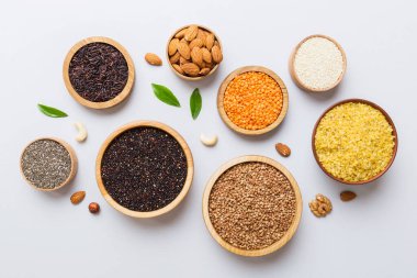 Smal Bowl 'da renkli arka planda çeşitli süper yiyecekler. Pirinç, chia, kinoa, mercimek, fındık, susam tohumu, badem gibi süper yiyecekler. üst görünüm kopyalama alanı.