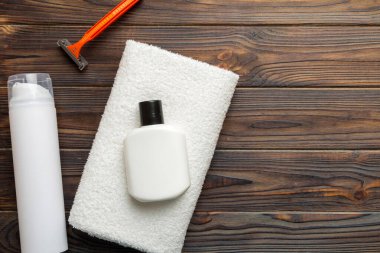 Tıraş Adam seti. Traş makinesi, havlu, losyon ve renkli arka planda tıraş köpüğü. Erkekler banyo aksesuarları üst görünüm.