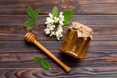 Akasya çiçekli ve yapraklı bal kavanozu. Taze bal üst görünüm düz yatıyordu.