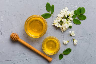 Akasya çiçekli ve yapraklı bal kavanozu. Taze bal üst görünüm düz yatıyordu.