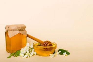 robinia honey bollte with acacacia flomes on color table.