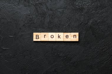 Tahta bloğa yazılmış kırık bir kelime. Çimento masasındaki kırık metin desing, konsept için.