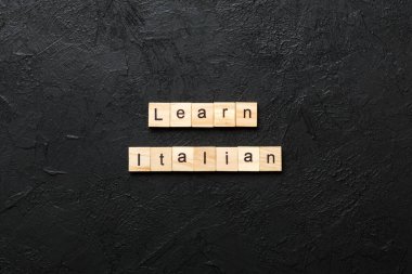 Tahta blokta yazılı İtalyanca kelime öğren. Masada İtalyanca metni, konsepti öğren.