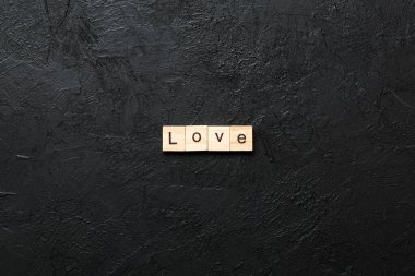 Tahta blokta yazılı aşk kelimesi. Masada aşk metni, konsept.