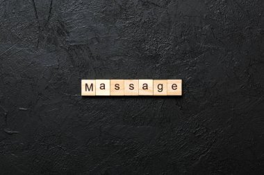 Tahta bloğa yazılmış masaj kelimesi. Masaj metni çimento üzerinde desing, konsept için.