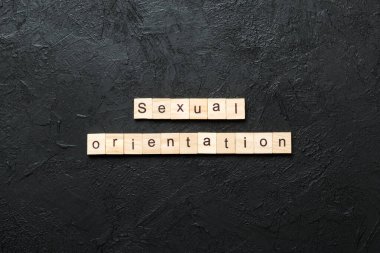 Tahta bloğa yazılmış cinsel yönelim kelimesi. Cinsel yönelim metniniz çimento üzerinde desing, kavram için.