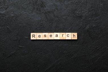 Tahta blokta yazan araştırma kelimesi. tablo üzerinde araştırma metni, konsept.