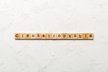Klostrofobi kelimesi tahta blokta yazılı. Masada klostrofobi metni, konsept.