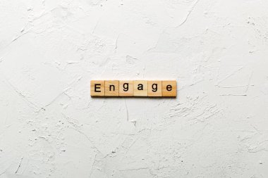 Tahta bloğa yazılmış bir nişan kelimesi. Deksing, konsept için çimento masadaki bağlanma metni.