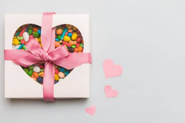 Valentine day composition: sweet candy, with gift boxes with bow and red felt hearts, photo template, background. Top View with copy space.