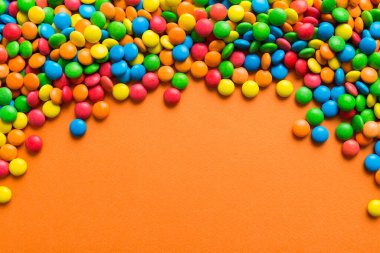 Renkli arka planda karışık renkli şeker koleksiyonu. Düz yerde, üst tarafta. Renkli çikolata kaplı şeker çerçevesi.
