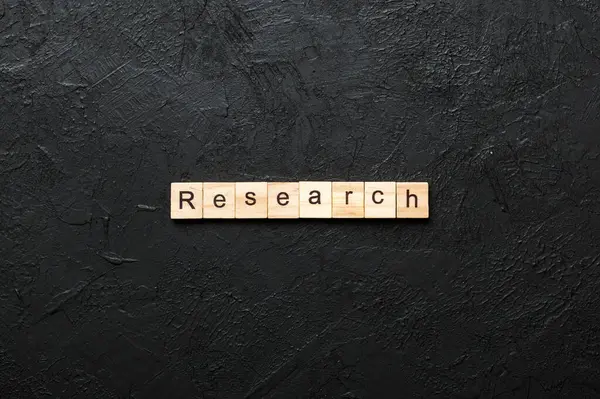 Tahta blokta yazan araştırma kelimesi. tablo üzerinde araştırma metni, konsept.