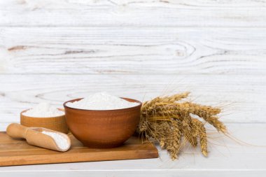 Tahta kasede buğday unu ve renkli arka planda buğday dikenleri. dünya buğday krizi.