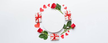 Renkli arka planda gül, oyuncak kutusu, kalp ve boş tebrik kartı modelinden yapılmış bir çerçeve. Top view, flat lay, copy space Holiday, Anneler Günü, doğum günü konsepti.