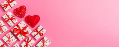 Hediye kutularının ve renkli arka planda kırmızı tekstil kalplerinin üst görüntüsü. Kopya alanı ile Sevgililer Günü konsepti.